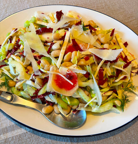 Photograph of a plate of KATZ Farm white bean salad, topped with thinly sliced radishes