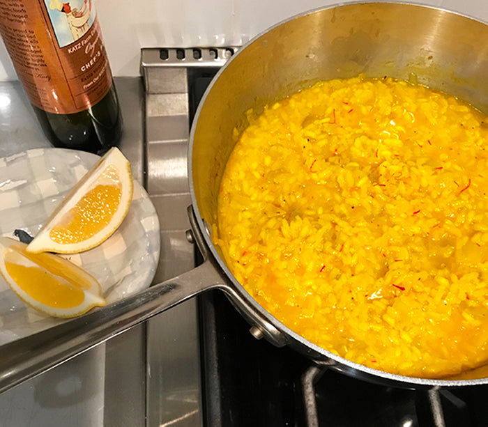 Pot of cooked risotto, with lemon wedges and a bottle of Katz Chef's Pick EVOO off to the side